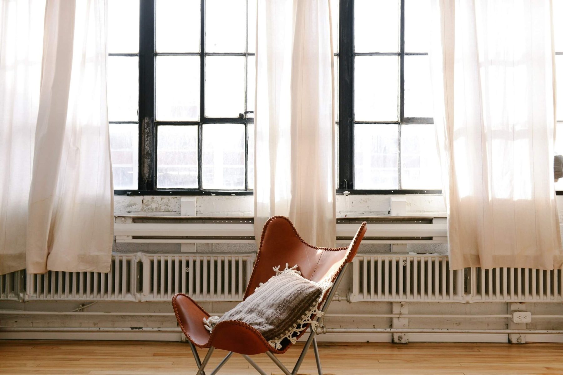 Bright room with tall windows and a leather chair